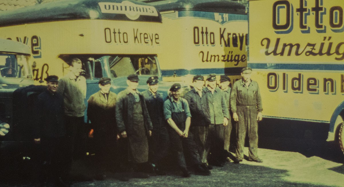 Das Bild zeigt alte LKWs und die ehemalige Belegschaft der Spedition Otto Kreye