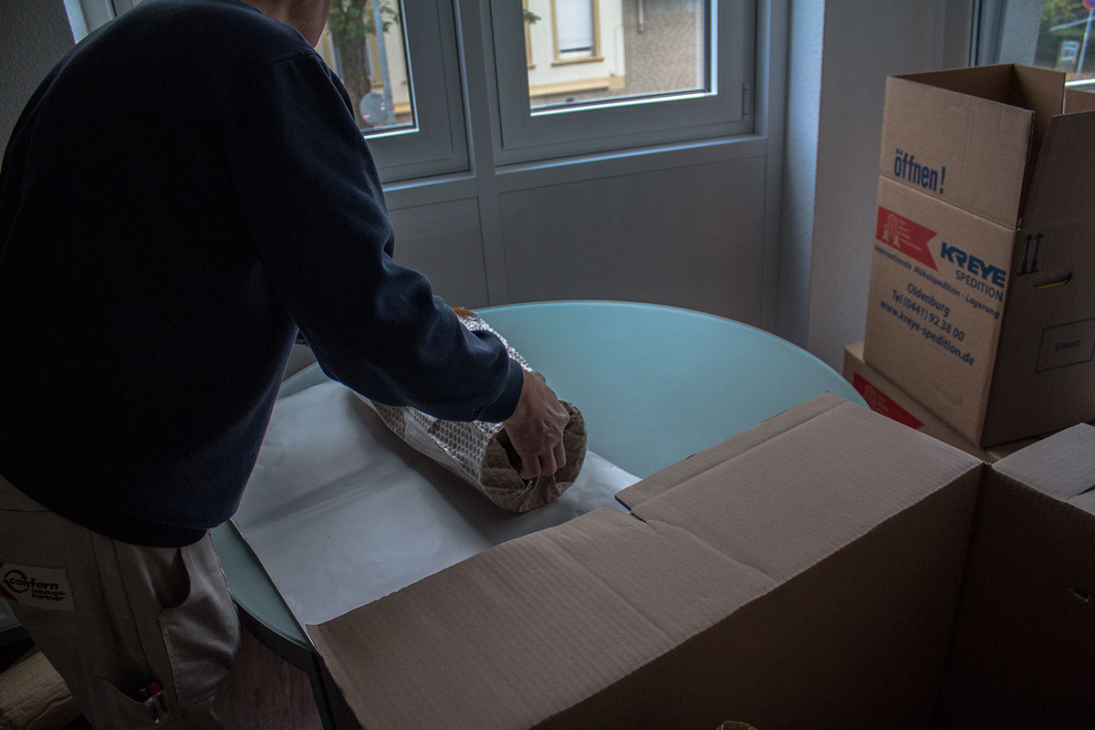 Das Bild zeigt einen Mitarbeiter der Spedition Kreye beim Verpacken des Umzugsgutes